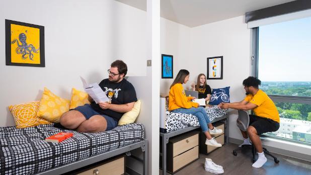 3 students sitting on beds in a bedroom of GRC